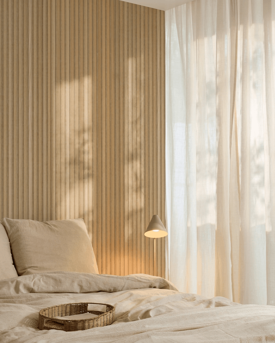Minimalist bedroom with a beige bed, Scandinavian design, sheer curtains, and a WoodUpp Akupanel acoustic panel in Carolina Oak and beige felt on the wall.